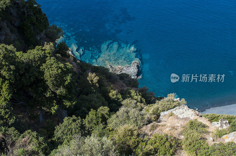 科西嘉岛:从空中俯瞰普拉格·德·诺扎(Plage de Nonza)，悬崖底部长长的黑色海滩上矗立着科斯角(Cap Corse)西海岸著名的村庄Nonza小镇